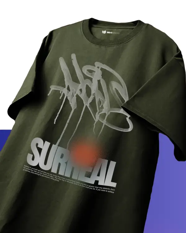 Oversized T-shirt laid flat with the word 'Surreal' printed in stylized typography, displayed on a plain background
