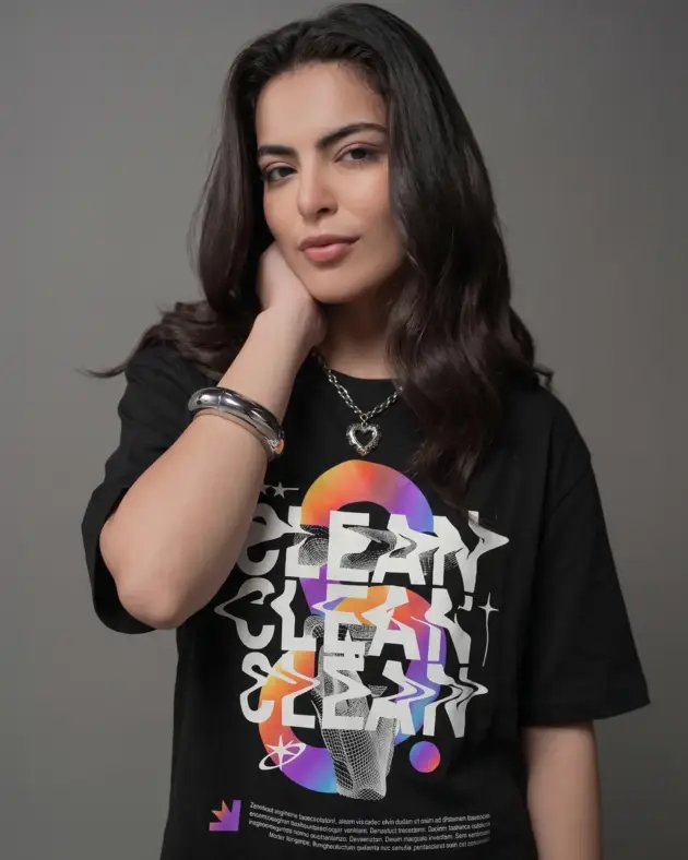 Medium shot of a model wearing a premium oversized black graphic t-shirt with a drop-shoulder fit, styled with silver accessories.