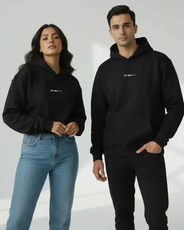 Black oversized unisex hoodie by Mintmacro worn by male and female models, featuring a relaxed fit minimalist streetwear design.