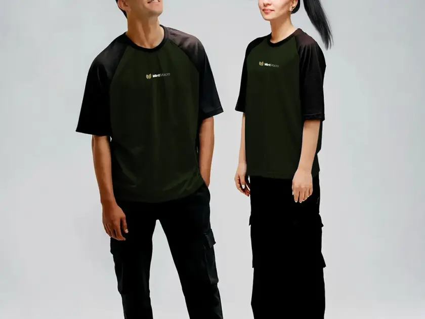 A man and a woman modeling dark olive green raglan t-shirts with black sleeves and "MintMacro" branding, paired with black cargo pants.