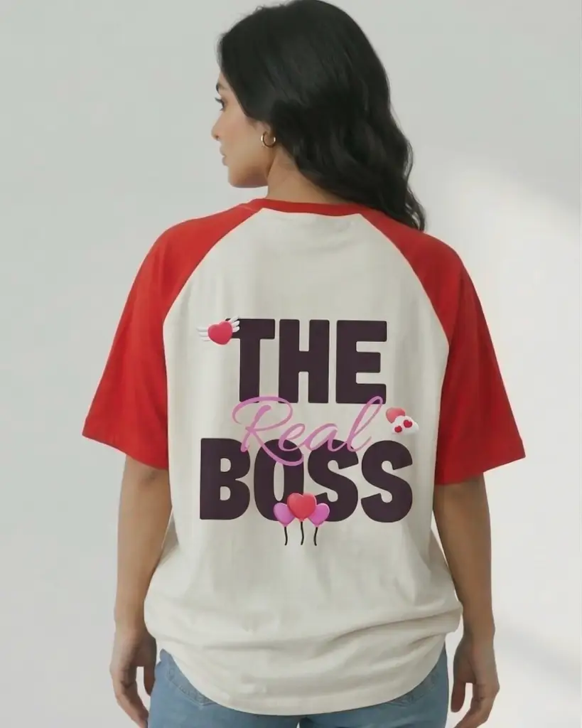Rear view of a woman wearing a red and white raglan t-shirt with "THE Real BOSS" printed on the back, featuring pink script and heart illustrations.