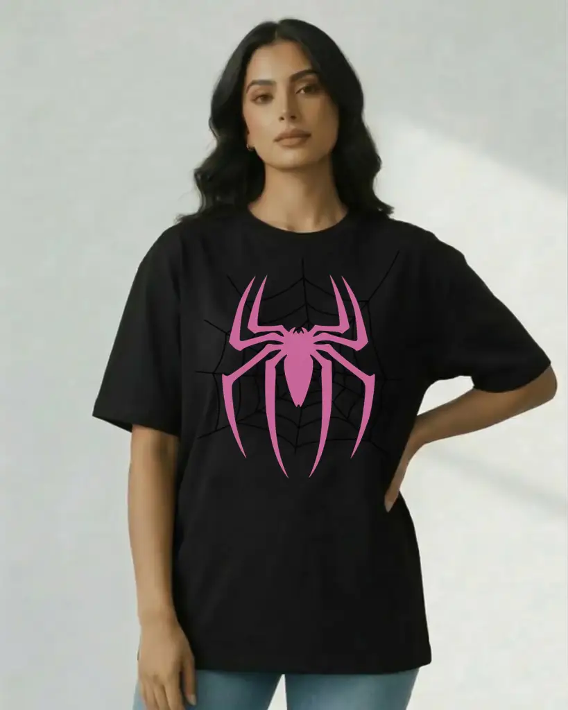 A woman posing in an oversized black t-shirt featuring a large, vibrant pink spider graphic overlaid on a subtle black spiderweb design.