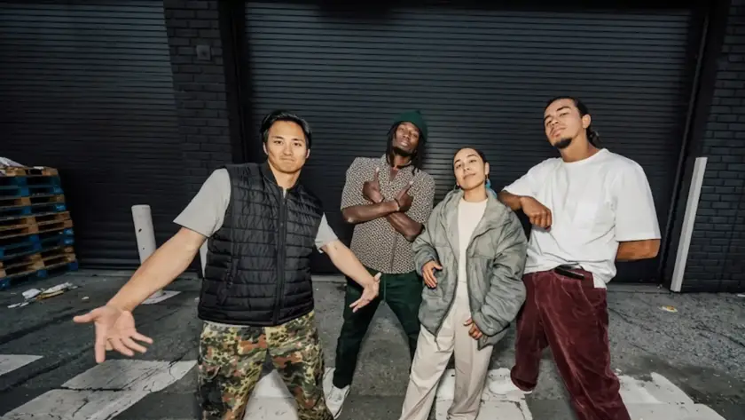 Four individuals posing in stylish, oversized streetwear clothing including a puffer jacket, cargo pants, and a gilet puffer vest in an urban outdoor setting.