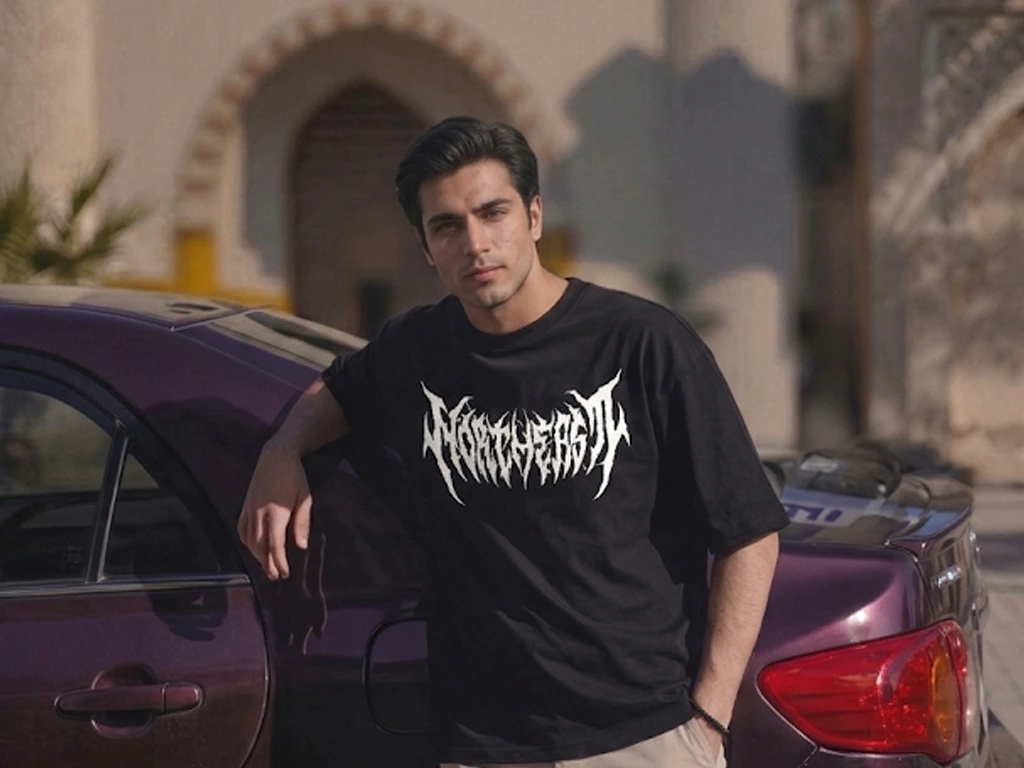 An oversized black crewneck t-shirt featuring a sharp, aggressive white death metal style font graphic across the chest.